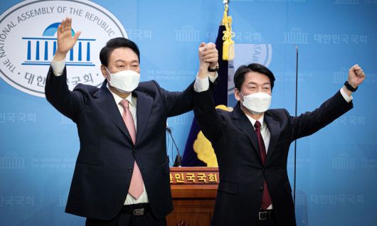 2022년 3월 3일 당시 윤석열 국민의힘 대선 후보, 안철수 국민의당 대선 후보가 서울 여의도 국회 소통관에서 단일화 기자회견을 마치고 손을 들어 올리고 있다. 공동취재