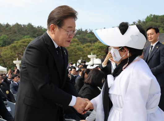 더불어민주당 이재명 대선후보(왼쪽)가 18일 광주 북구 국립 5∙18 민주 묘지에서 열린 ‘5∙18민주화운동 기념식’에서 오월 어머니회 회원과 인사하고 있다. 대통령실사진기자단