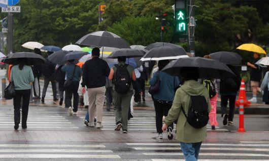 지난 15일 서울 종로구 광화문 네거리에 우산을 쓴 시민들이 발걸음을 재촉하고 있다. 뉴시스