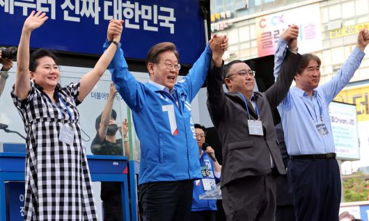 더불어민주당 이재명 대선후보가 21일 인천시 서구 롯데마트 청라점 앞에서 열린 유세에서 찬조연설자들과 손을 들어 지지자들에게 인사하고 있다. 인천=허정호 선임기자