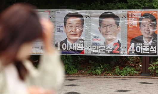 제21대 대선을 열하루 앞둔 23일 서울 마포구 공덕오거리 인근에 걸린 대선 후보 벽보 앞으로 시민이 지나고 있다. 연합뉴스