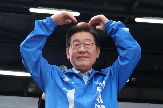 더불어민주당 이재명 대선 후보가 26일 경기 수원시 팔달문 영동시장 입구에서 열린 집중유세를 마친 뒤 시민들에게 하트를 그려 보이고 있다. 공동취재