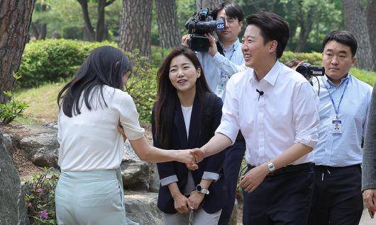 “순화해 표현한 건데… 불편한 국민들에 사과” 개혁신당 이준석 대선 후보(앞줄 오른쪽)가 28일 서울 영등포 여의도공원에서 산책 나온 직장인과 악수하며 지지를 호소하고 있다. 이재문 기자