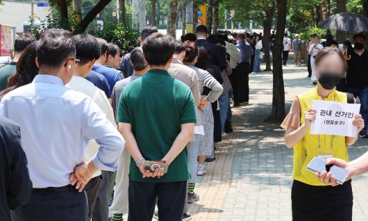 제21대 대통령 선거 사전투표 첫날인 29일 사전투표소가 설치된 서울 영등포구 여의동 주민센터 앞에 직장인들이 점심시간을 이용해 투표하기 위해 길게 줄지어 서 있다. 연합뉴스