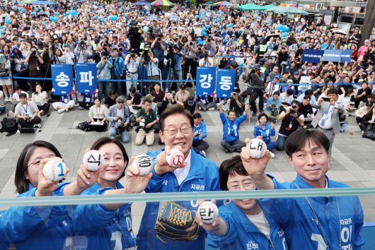 더불어민주당 이재명 대선 후보가 29일 서울 송파구 잠실종합운동장 광장에서 열린 강동구·송파구 집중유세에서 '내란종식'이 쓰여있는 야구공을 들고 포즈를 취하고 있다.   연합뉴스