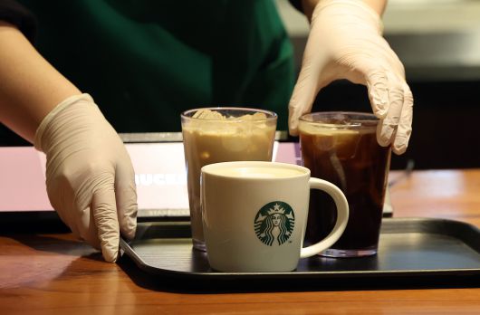 서울 시내 한 스타벅스 매장에서 직원이 커피 음료를 고객에 제공하고 있다. 뉴스1