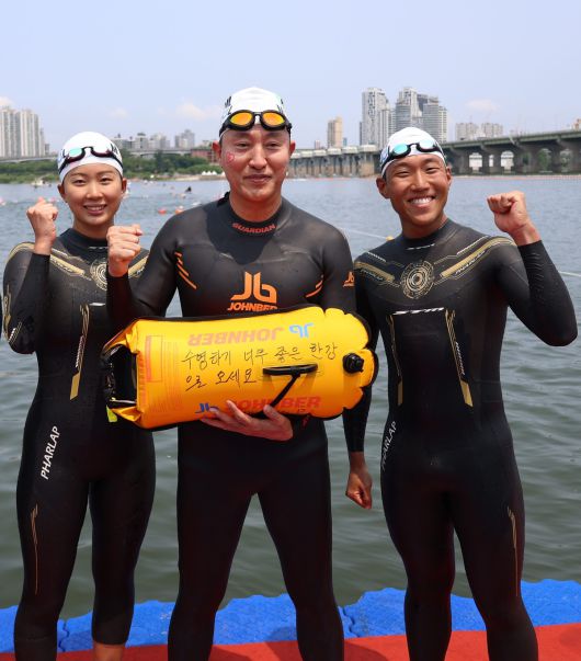 오세훈 서울시장이 30일 광진구 자양동 뚝섬한강공원에서 ‘쉬엄쉬엄 한강 3종 축제’ 1일차 수영종목에 출발 전 ‘수영하기 너무 좋은 한강으로 오세요 수질 환상적!’ 안전부이를 들고 도강을 준비하고 있다. 서울시 제공