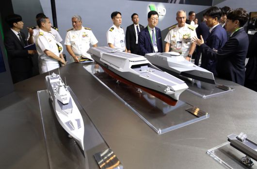지난달 28일 부산 해운대구 벡스코 제1전시장에서 열린 2025 국제해양방위산업전(MADEX)에서 참가자들이 HD현대중공업 부스를 찾아 미래형 무인전력모함 등을 살펴보고 있다. 부산=뉴스1