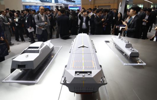 지난달 28일 부산 해운대구 벡스코 제1전시장에서 열린 2025 국제해양방위산업전(MADEX)에서 참가자들이 HD현대중공업 부스를 찾아 미래형 무인전력모함 등을 살펴보고 있다. 부산=뉴스1
