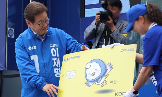 5월 20일 당시 더불어민주당 이재명 대선 후보가 경기 파주시 금릉역 중앙광장에서 열린 유세에서 지역화폐 모형을 전달받고 있다. 연합뉴스