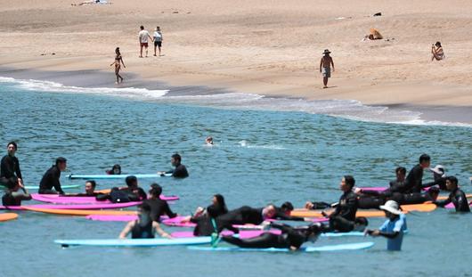 여름 날씨를 보인 5일 제주 서귀포시 중문색달해수욕장에서 물놀이객이 백사장 위를 걸어가고 있다. 뉴시스