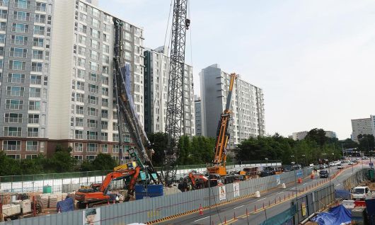 6일 경기 용인시 기흥구 서천동 인덕원~동탄 복선전철 공사 현장에서 중장비인 천공기가 넘어져 인근 아파트 건물 벽면에 기댄 모습으로 쓰러져 있다. 연합뉴스