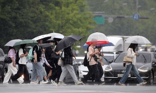 지난 13일 대구 달서구 계명대 성서캠퍼스 앞 도로에서 장맛비를 피해 우산을 쓴 시민들이 발걸음을 재촉하고 있다. 뉴스1