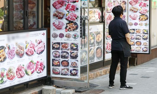내수 경기 침체 장기화로 인해 숙박·음식점업 대출 잔액이 처음으로 90조 원을 넘어서면서 소상공인 위기가 깊어지고 있다. 지난 12일 서울 중구 명동의 한 식당에서 한 자영업자가 손님을 기다리고 있다. 뉴스1