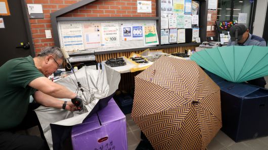 장마철이 다가오는 가운데 16일 서울 중랑구 망우동 망우마중마을 활력소에 마련된 '중랑구 2025 찾아가는 우산수리·칼갈이 서비스'에서 우산수리 기술자들이 구민이 접수한 고장난 우산을 수리하고 있다. 이제원 선임기자