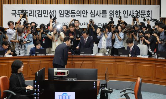 김민석 국무총리 후보자가 24일 서울 여의도 국회에서 열린 인사청문회에서 총리 후보자 인사청문특별위원회 위원장인 국민의힘 이종배 의원에게 선서문을 제출한 뒤 인사하고 있다. 연합뉴스