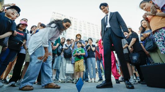 29일 서울 종로구 광화문광장에서 '2025 K콘텐츠 서울여행주간: 소울스팟을 찾아라' 행사의 일환으로 마련된 넷플릭스 오징어 게임 체험존에서 외국인 관광객이 딱지치기를 하고 있다.