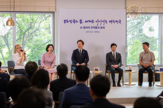 이재명 대통령(가운데)이 지난달 30일 서울 용산 대통령실 파인그라스에서 열린 문화예술계 수상자 간담회에서 조수미 성악가의 발언을 들으며 미소를 짓고 있다. 대통령실 제공