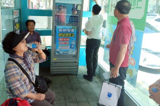 전북 고창군 한 무더위 쉼터에 비치된 양심냉장고에서 주민들이 생수로 더위를 식히고 있다. 고창군 제공