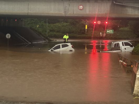 17일 호우경보가 내려진 충남 서산시 운산면 운산교차로 지하차도에 침수가 발생해 차량 2대가 물에 잠겨있는 가운데 스파크 운전자가 차 위에서 구조를 기다리고 있다. 뉴시스