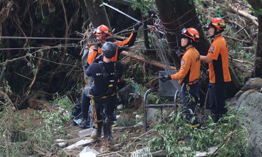 소방대원들이 지난 20일 산사태가 발생한 경기 가평군 마일리 내 한 펜션에서 고립자 구조작업을 펼치고 있다. 뉴시스