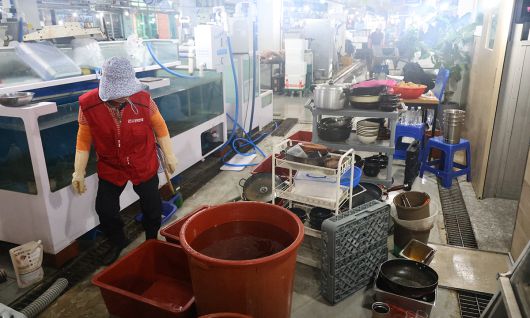 지난 18일 오전 집중호우로 침수된 충남 당진시 읍내동 당진어시장에서 한 상인이 침수 피해를 본 집기류를 세척하고 있다. 연합뉴스