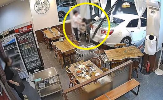 지난 11일 오후 인천 서구 청라동의 한 중식당 통유리를 깨고 승용차가 돌진하자 식사 중이던 커플이 황급히 대피하는 모습. 연합뉴스