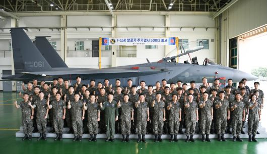 부품정비대대가 격납고에서 F-15K 주기검사 500대 출고 달성을 기념헤 단체 기념 촬영을 하고 있다. 제11비 제공