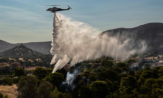 9일 아테네 인근 팔라이아 포카이아에 발생한 산불에 소방헬기가 물을 뿌리고 있는 모습. 아테네=AFP연합뉴스