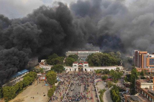 네팔 시위대가 지난 9일 수도 카트만두에서 SNS 금지 및 부패에 대한 항의 시위 중 의회 건물이 불타자 축하하고 있다. AP