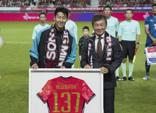 한국 남자 선수 A매치 최다 출전한 손흥민이 14일 오후 서울 마포구 서울월드컵경기장에서 열린 하나은행 초청 축구국가대표팀 친선경기 대한민국과 파라과이의 경기 시작 기념 유니폼을 전달받고 정몽규 축구협회장과 기념촬영을 하고 있다. 손흥민은 지난 10일 브라질전에 개인 통산 137번째 A매치에 출전했다. 차범근 전 대표팀 감독, 홍명보 대표팀 감독(이상 136경기)을 제치고 한국 남자 축구 역사상 최다 출전 기록 보유자가 됐다. 2010년 12월 시리아전 데뷔 이후 15년 만이다. 뉴시스