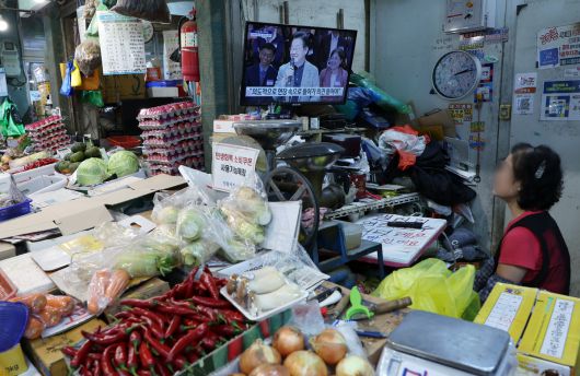 지난 14일 오후 서울시 서대문구 인왕시장 한 채소 매장 TV에 지역 상권 활성화와 소비쿠폰을 주제로 한 ‘디지털 토크 라이브’ 생중계가 틀어져 있다. 뉴스1