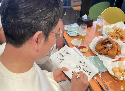 이재용 삼성전자 회장이 30일 서울 삼성동 한 치킨집에서 진행된 젠슨 황 엔비디아 최고경영자, 정의선 현대차그룹 회장과의 치맥 회동에서 한 어린이에게 사인을 해주고 있다. 연합