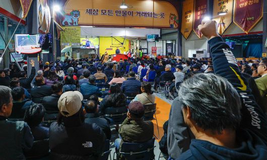 박영걸 만물도깨비경매장 회장이 경기 용인시 처인구 만물도깨비경매장에서 경매를 진행하는 가운데 입찰자들이 손을 들어 구매 의사를 밝히고 있다.