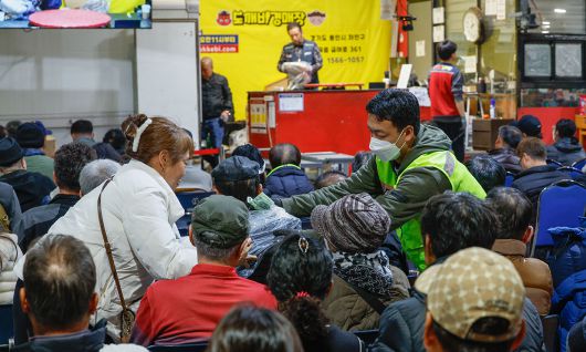 경기 용인시 처인구 만물도깨비경매장에서 경매 중 후라이팬 입찰에 성공한 시민이 물품을 받고 있다.