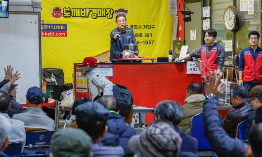 박영걸 만물도깨비경매장 회장이 경기 용인시 처인구 만물도깨비경매장에서 경매 중 먼저 손을 든 입찰자를 가리키고 있다.