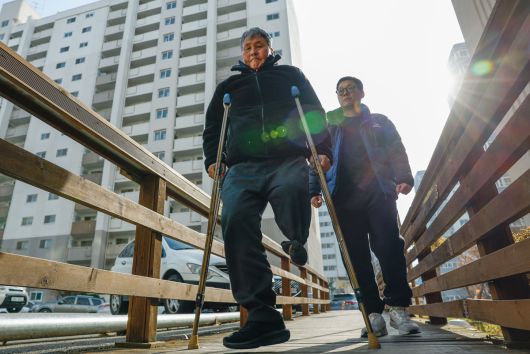 지난 10일 전북 전주시 완산구 평화동의 한 아파트 단지에서 김석곤(70·왼쪽)씨가 아들 종현(42)씨와 함께 걷고 있다. 김씨는 2년 전 새벽 음식물 쓰레기 수거 업무 중 음주운전 뺑소니 사고로 왼쪽 다리를 잃었다. 전주=최상수 기자