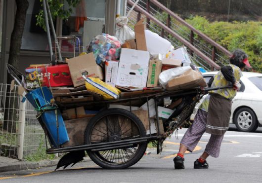 서울의 한 거리에서 어르신이 폐지가 가득 실린 리어카를 끌고 있다. 뉴스1