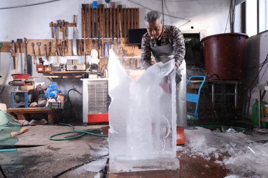 문성호(52) 얼음조각가가 부산 초읍동 작업장에서 얼음조각을 하고 있다. 머릿속에서 미리 구상한 뒤 전기톱으로 절단하자 봉황 윤곽이 드러났다. 그 뒤로는 얼음조각을 위해 쓰이는 조각칼들이 벽면에 걸려 있다.
