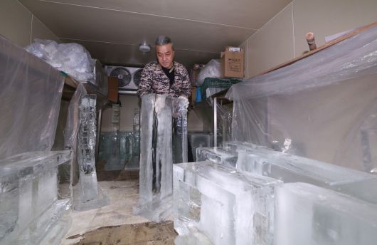 문성호 얼음조각가가 작업장 냉동창고에서 작업을 위해 얼음을 꺼내고 있다.