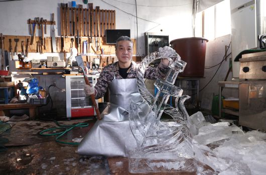 문성호 얼음조각가가 ‘닻’ 형태의 얼음조각 작품을 완성한 뒤 조각칼을 들고 포즈를 취하고 있다. 이 얼음조각은 부산의 한 선박업체에서 의뢰받은 작품이다.