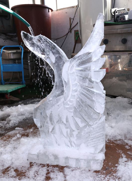 완성된 얼음조각 작품에 물을 뿌리고 있다. 작업할 때 나온 얼음가루들을 세척하기 위해서다.