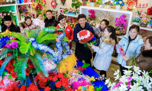 새해를 앞두고 북한 사람들이 31일 꽃매대를 찾고 있다. 평양 노동신문·뉴스1