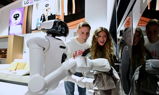 LG전자의 홈 로봇 ‘LG 클로이드’가 세탁물 바구니에서 빨랫감을 꺼내 세탁기에 넣는 모습. LG전자 제공