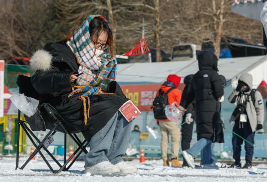 11일 강원 화천군 화천읍 화천천 일대에서 2026 얼음나라화천 산천어축제가 열린 가운데 행사장을 찾은 한 외국인 관광객이 얼굴에 목도리를 두른 채 산천어 낚시를 즐기고 있다.