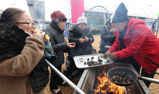 겨울 테마파크 2026 노원 눈썰매장 장애인 가족 초청행사가 열린 12일 서울 노원구 한국과학기술대학교에 마련된 행사장에서 참가자들이 군밤 굽기 체험을 하고 있다.