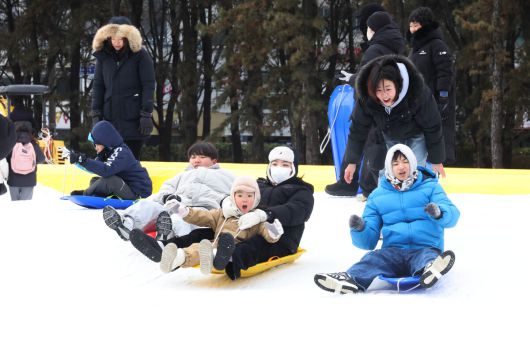 겨울 테마파크 2026 노원 눈썰매장 장애인 가족 초청행사가 열린 12일 서울 노원구 한국과학기술대학교에 마련된 행사장에서 참가자들이 눈썰매를 타고 있다.