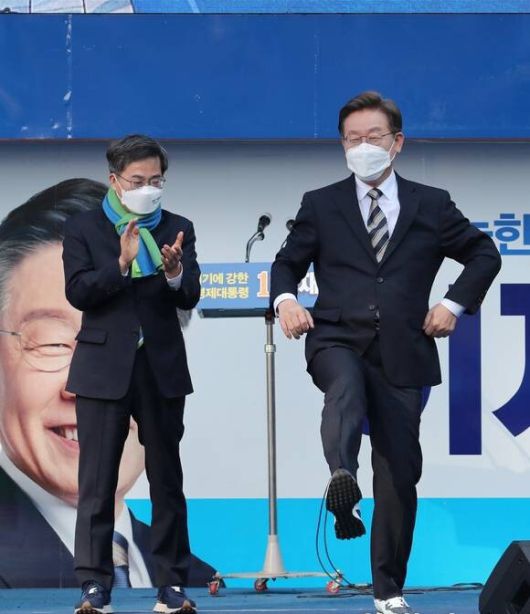 2022년 3월3일 이재명 당시 민주당 대선 후보가 서울 영등포 타임스퀘어 광장에서 집중 유세를 벌이던 중 김동연 전 새로운물결 후보로부터 선물 받은 운동화를 신어보고 있다. 국회사진취재단