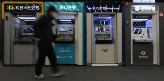 한 시민이 서울 건물에 설치된 은행 ATM 앞을 지나가고 있다. 뉴시스
