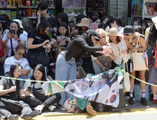 11일 방탄소년단(BTS)의 지민과 정국이 군 복무를 마치고 만기 전역했다. 지민과 정국의 전역을 축하하기 위해 서울 용산구 하이브 사옥인근에 글로벌 아미들이 모였다. 팬들이 기념사진을 찍고 있다. 김용학 기자